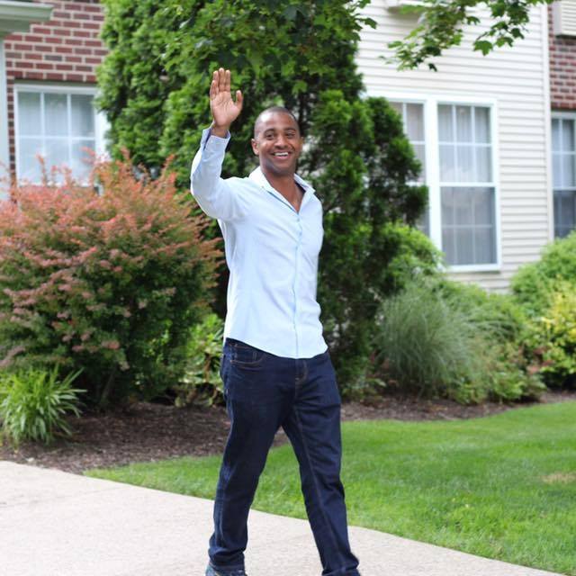 This image of Yan Garcia waving is beside the About Yan text description on the About Yan page. Yan Garcia is a Suffern, NY based ENL Teacher and Soccer Coach.